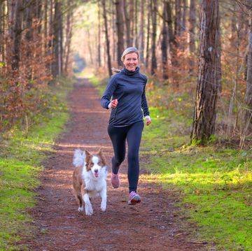 healthy fit woman running with her dog