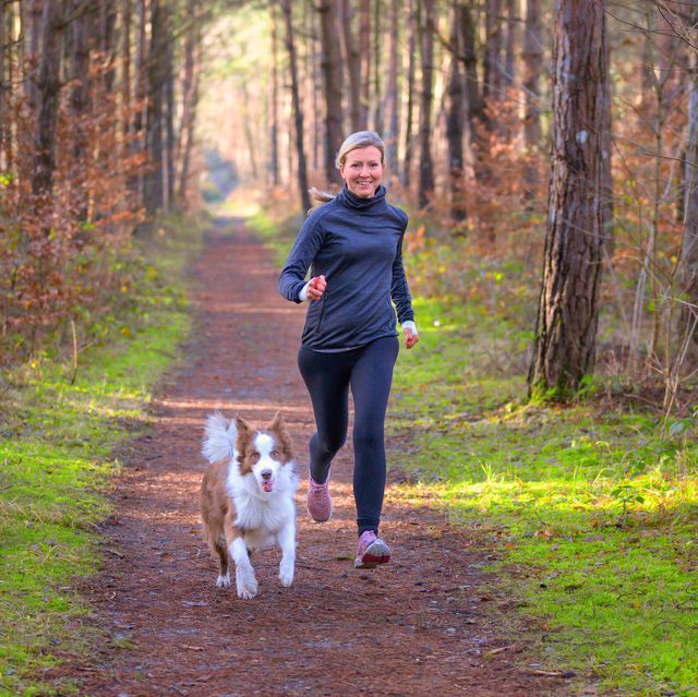healthy fit woman running with her dog