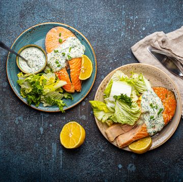 healthy food meal grilled salmon steaks with dill sauce and salad leafs on two plates