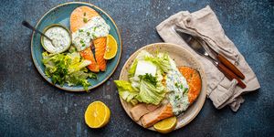 healthy food meal grilled salmon steaks with dill sauce and salad leafs on two plates