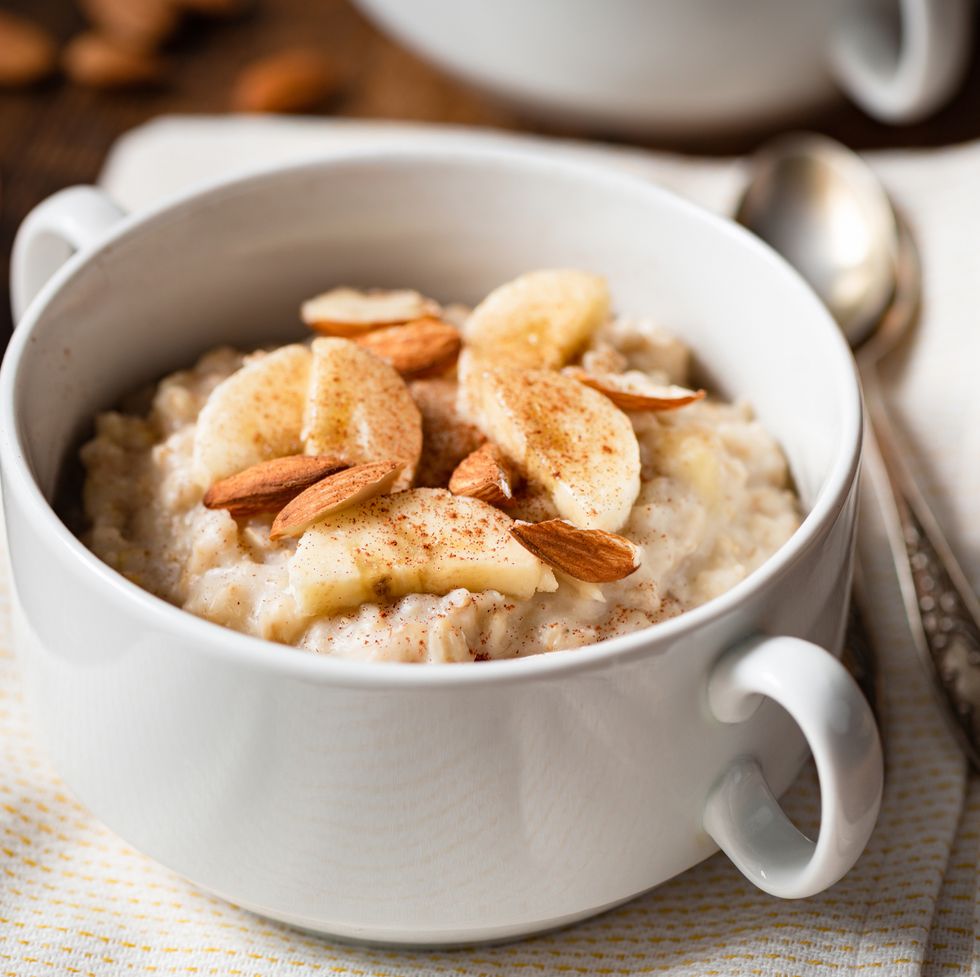 oatmeal porridge with banana, cinnamon and almonds in white bowl healthy breakfast food