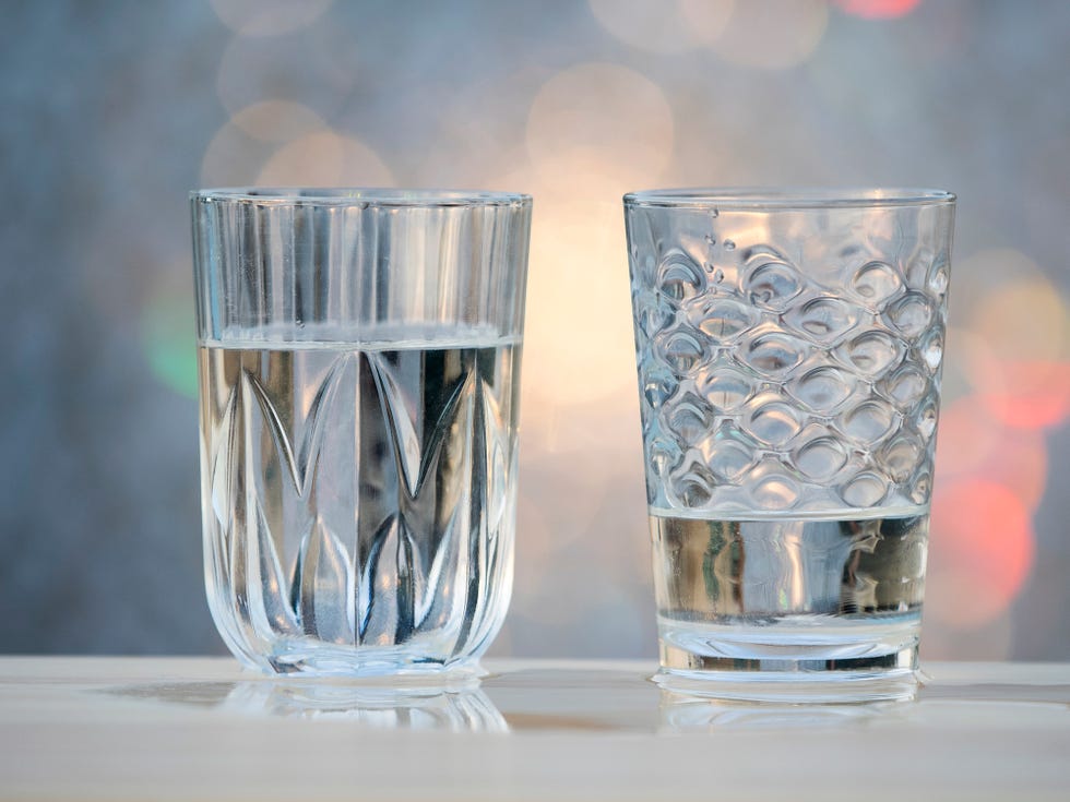water glasses on a wooden table outdoors illuminated by sunlight