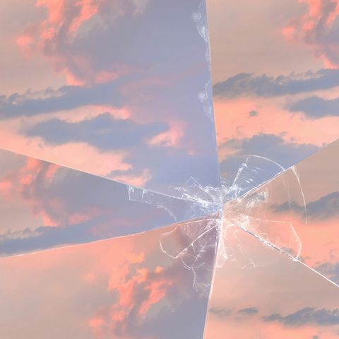A sunset and cloudy sky with broken glass