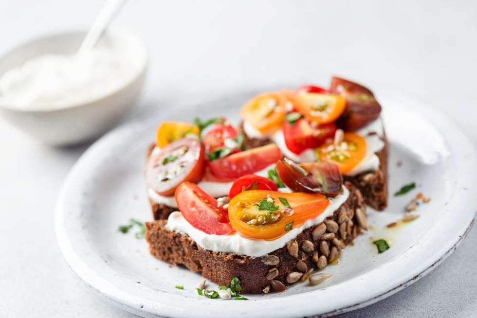 healthy rye bread toast with soft white cheese and tomatoes