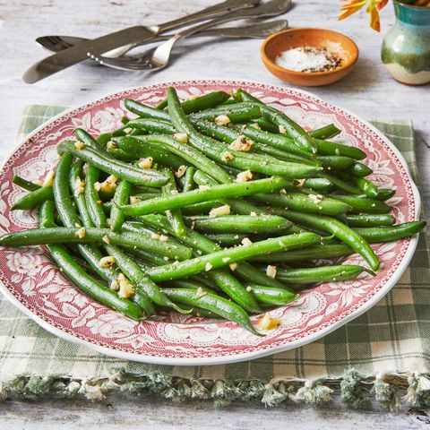garlic green beans on red and white plate