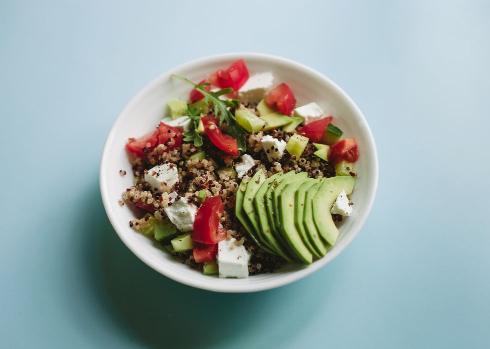 healthy vegetarian meal made of grain crop quinoa seed, avocado, cheese, cucumber and tomato