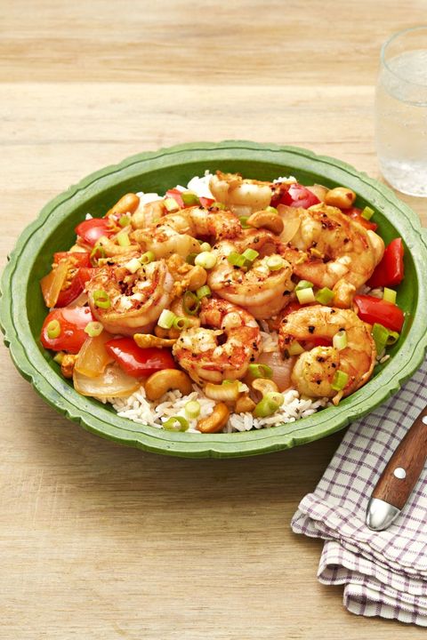 spicy cashew shrimp over rice in green bowl