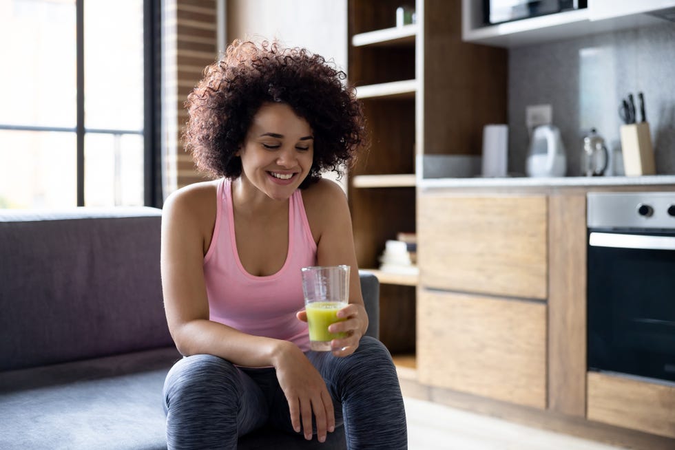 healthy woman drinking a green smoothie