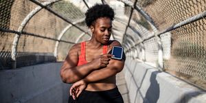 healthy woman using phone on armband before exercising