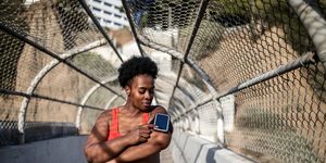 healthy woman using phone on armband before exercising