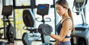 healthy women exercising with dumbbells at gym
