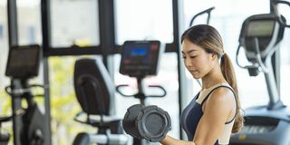healthy women exercising with dumbbells at gym