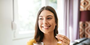 healthy young woman taking herbal supplements