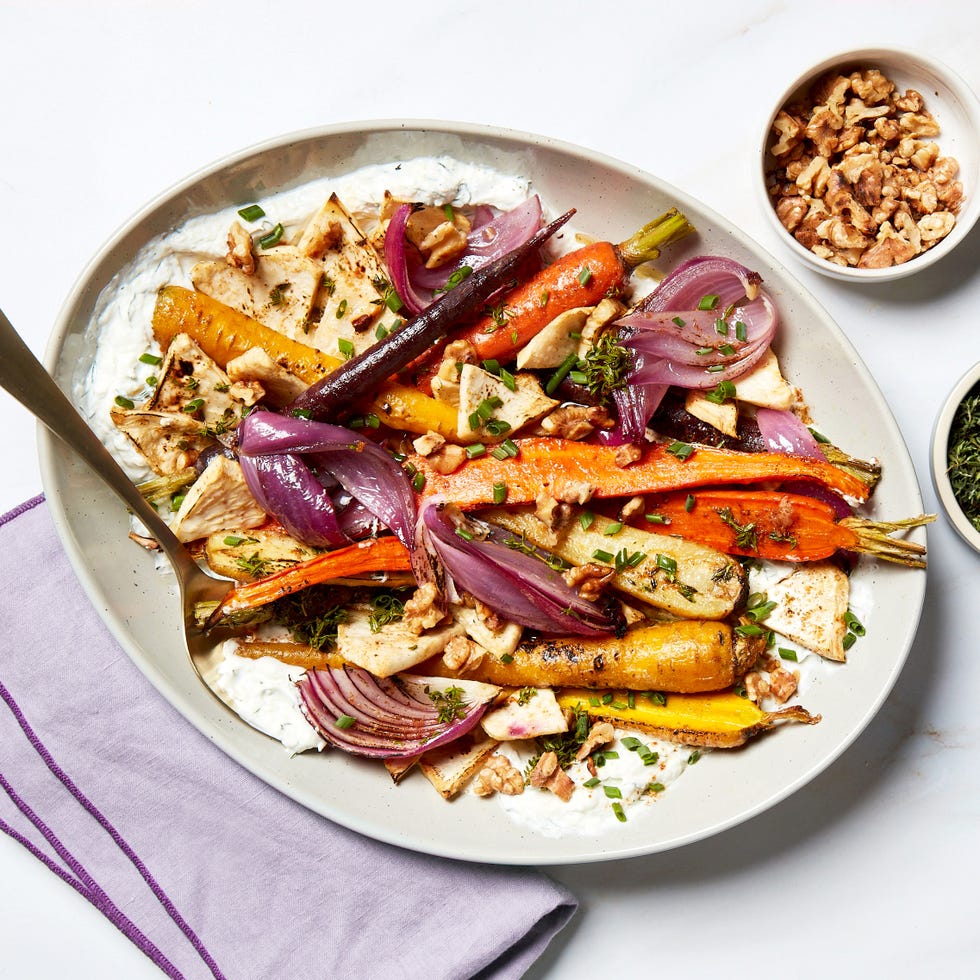 roasted vegetables served on a plate with yogurt and walnuts