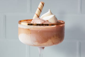 dessert in a glass bowl topped with whipped cream and a decorative wafer