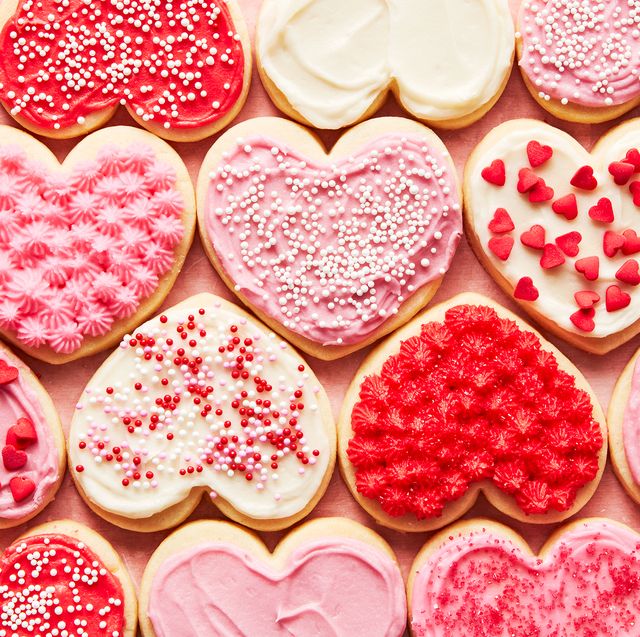 heart shaped sugar cookies iced with red, white, and pink frosting and sprinkles