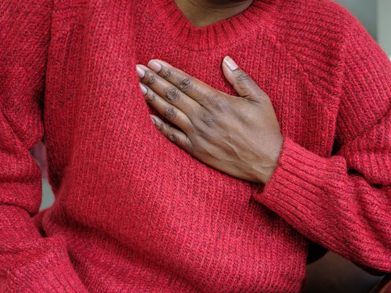 close up of unrecognizable black woman holding her chest in pain