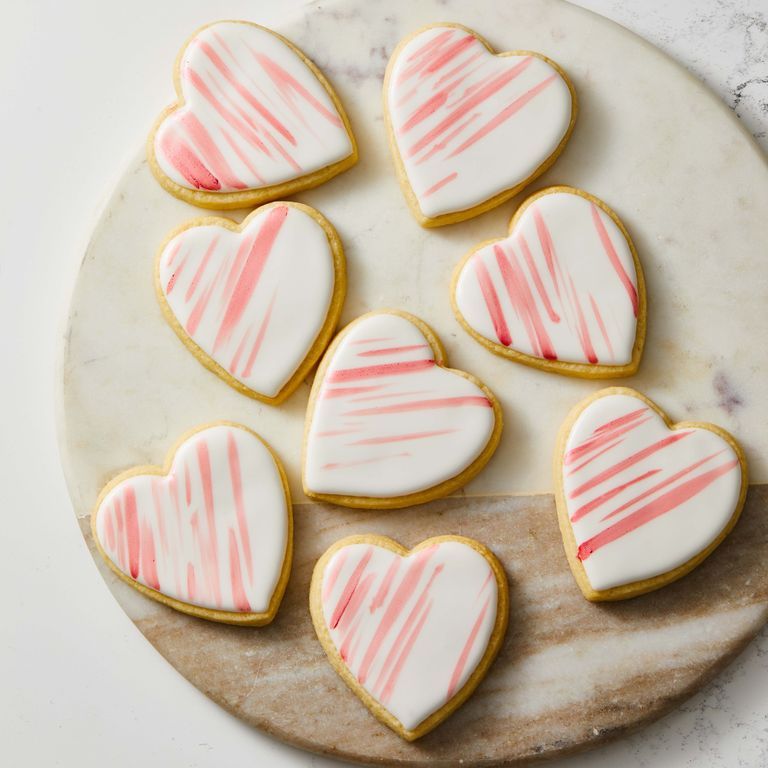heart shaped sugar cookies with pink stripes on royal icing