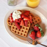 heart shaped waffles topped with fresh strawberries and whipped cream perfect for mothers day or valentines day