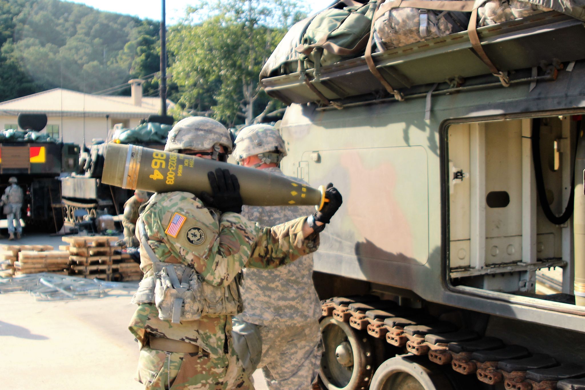 us army soldiers carry m864 cluster munition round to m992 artillery support vehicle