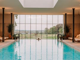indoor swimming pool with large windows overlooking a scenic view