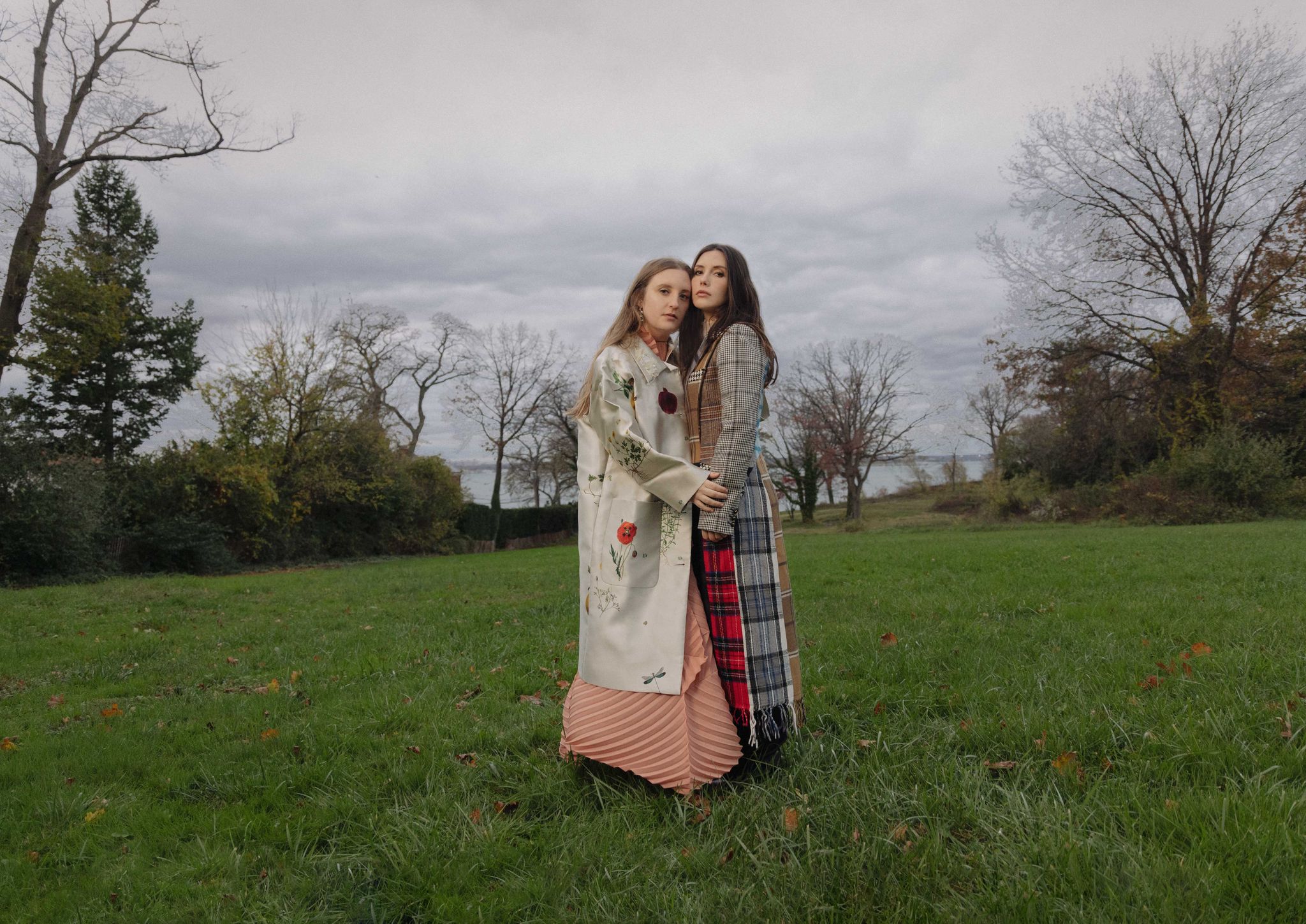 olivia and emma handler stand in a grassy field