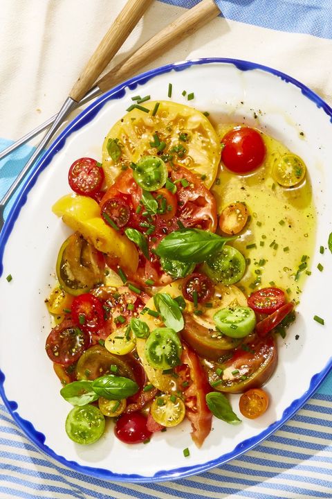 heirloom tomato salad drizzled in olive oil and topped with fresh herbs