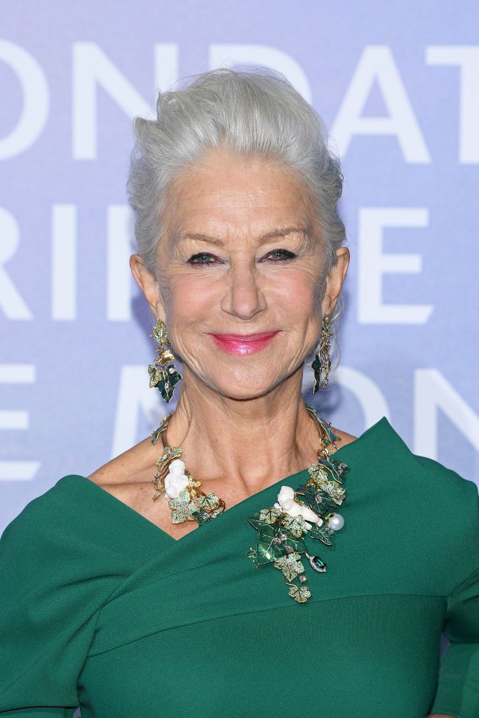 helen mirren poses on the red carpet wearing a green dress and lots of green jewelry