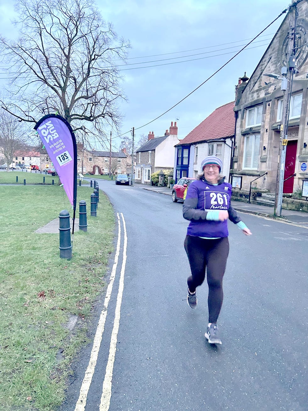 woman running along a village road in a race
