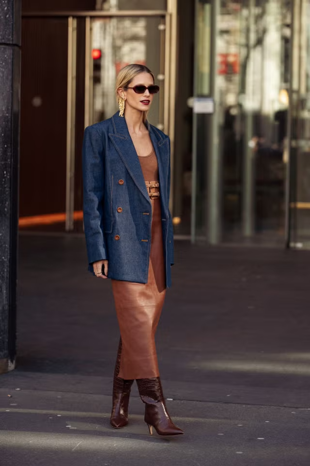 Femme dans des vêtements à la mode, debout à l'extérieur d'un bâtiment