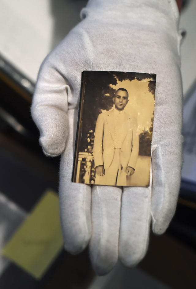 a sepia tinted photograph of raymond parks behind held by a gloved hand