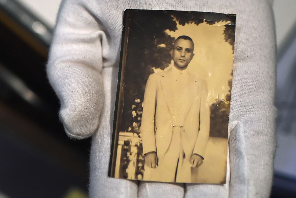 a sepia tinted photograph of raymond parks behind held by a gloved hand