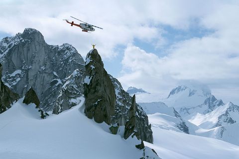 Een skigids die door een helikopter is afgezet staat op de Osprey Spire in de Canadese Purcell Mountains