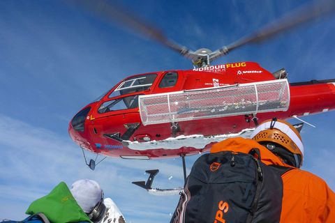 Een helikopter vliegt weg nadat hij skirs heeft afgezet op het schiereiland Troll in IJsland
