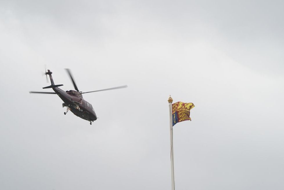 a helicopter flying over a flag