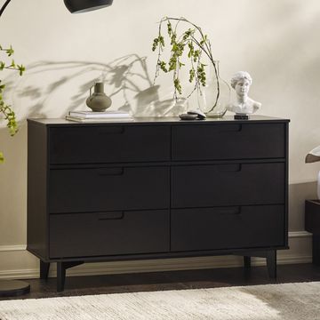 a black dresser with a plant on top