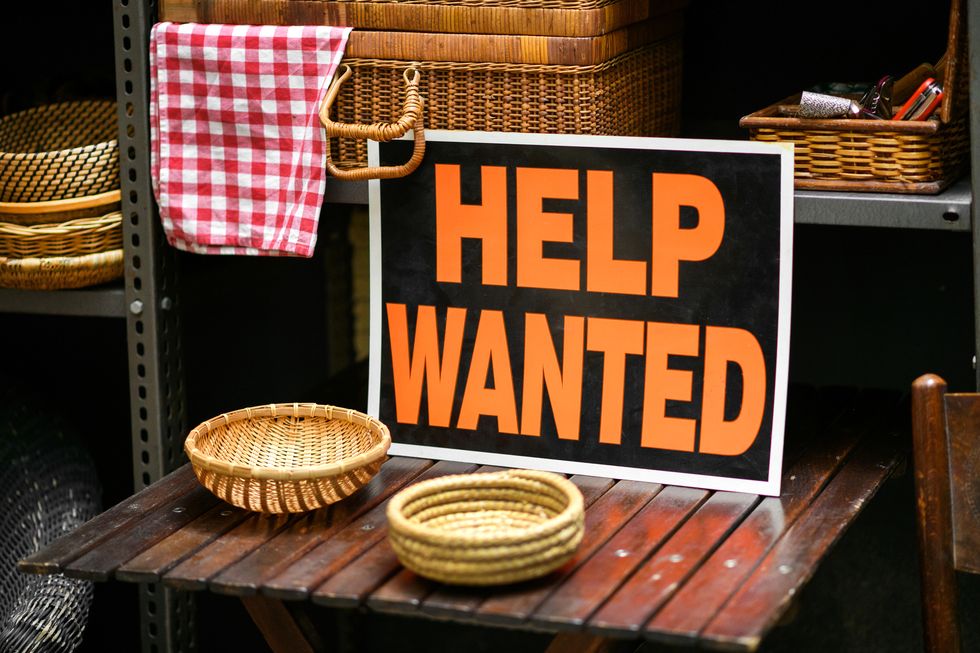 help wanted sign displayed in a shop in a job vacancy concept