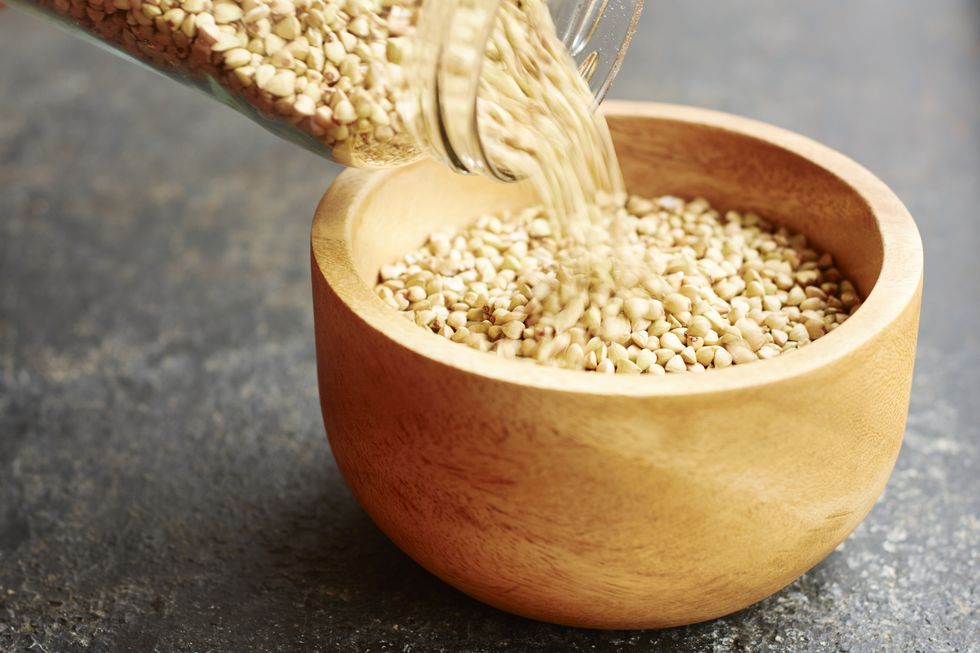 hemp seeds being poured into a wooden bowl