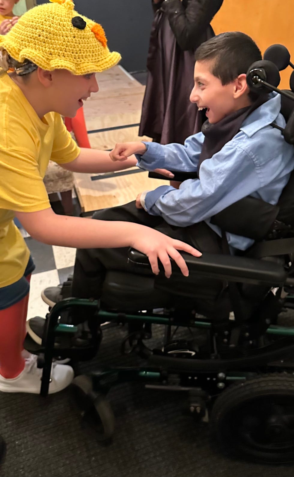 hernry in his wheelchair talking to a child in a yellow duck costume