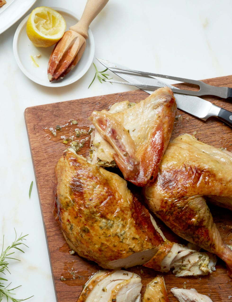 herb and lemon stuffed turkey on a butcher board