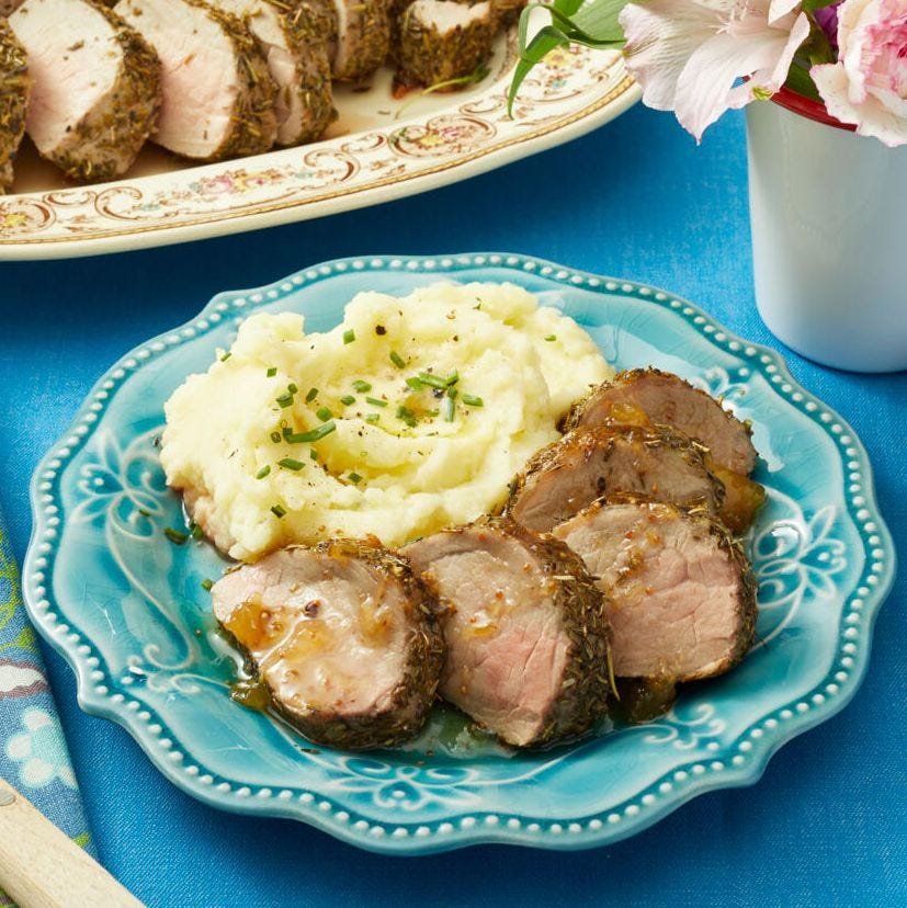 roasted pork tenderloin with preserves sliced on blue plate with mashed potatoes