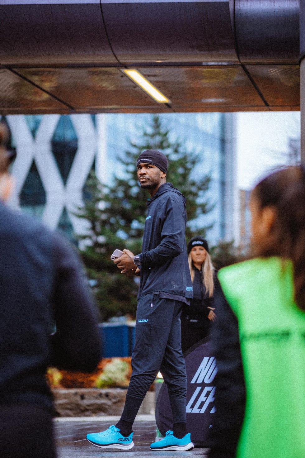 runner standing in front of others in an urban environment