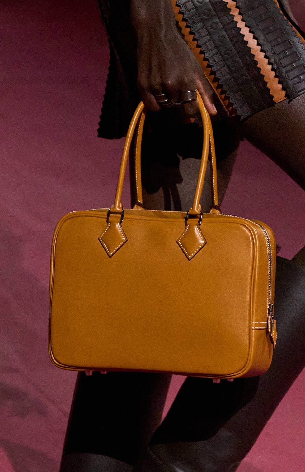 A stylish brown handbag being held