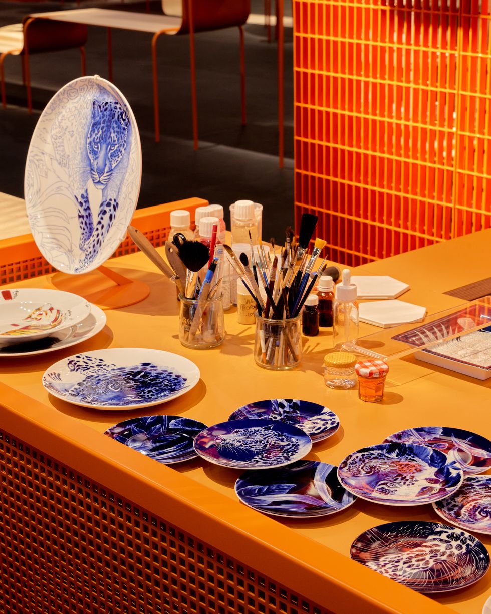 a set of painted hermes plates resting on a work station to illustrate a gallery from the hermes in the making exhibition 2022