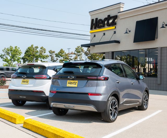 a acme  achromatic  2023 chevrolet bolt ev and a grey  shade  metallic 2023 chevrolet bolt euv parked successful  beforehand   of a hertz rental determination  successful  michigan hertz volition  statesman  taking deliveries of the chevrolet bolt ev and bolt euv successful  the archetypal  4th   of 2023