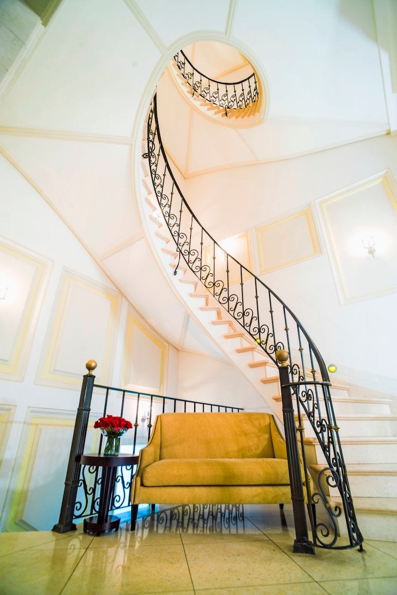 Een elegante trap wentelt zich omhoog in hotel Casa Gangotena