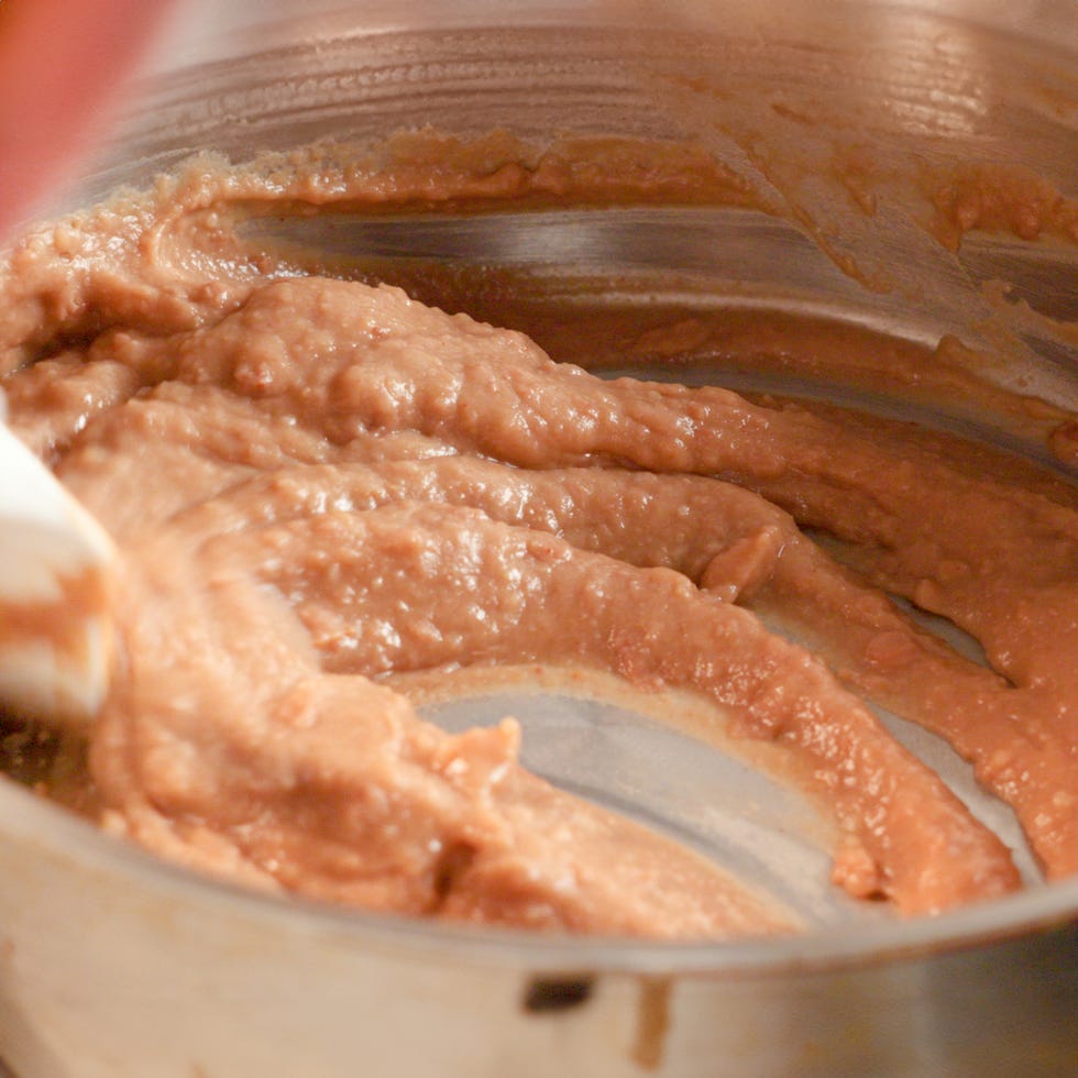 cooking refried beans in a skillet