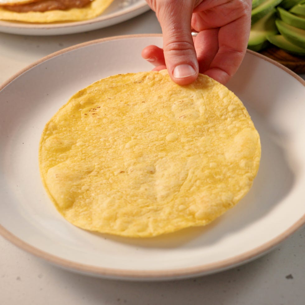 placing a toasted tortilla on a plate
