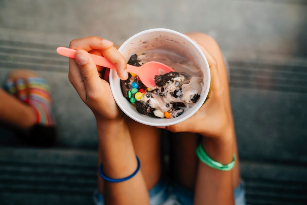 high angle close up of girl sitting on steps eating ice cream