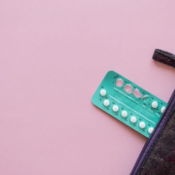 High Angle View Contraceptive Pill And Purse Over Pink Background